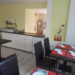 a kitchen with a table and chairs and a kitchen with a refrigerator at Haus Hillebrand in Bad Honnef am Rhein