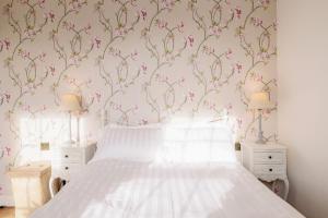 a bedroom with a bed with pink floral wallpaper at Pass the Keys Stylish Apartment in the heart of Clerkenwell in London