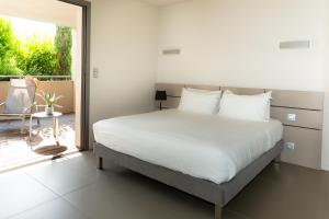 um quarto com uma cama grande e uma varanda em Costa Nera em Porto-Vecchio