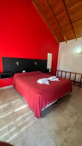 1 dormitorio rojo con 1 cama con pared roja en Apart Hotel Nonquen en Merlo