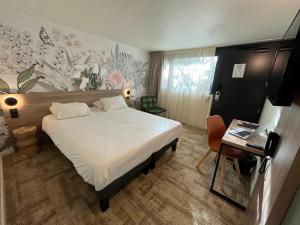 維托勒的住宿－Kyriad Vitrolles Aéroport Marseille，酒店客房带一张床铺、一张书桌和一间卧室