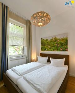 a bedroom with a large white bed and a window at Haus Inselrose Ferienwohnung Wildrose in Juist