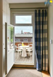 a door leading to a balcony with a table and chairs at Haus Inselrose Ferienwohnung Wildrose in Juist +24 photos