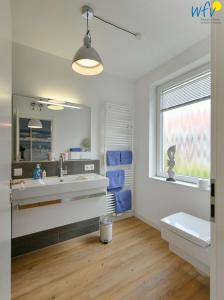 a bathroom with a sink and a toilet and a window at Haus Inselrose Ferienwohnung Wildrose in Juist