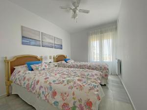 sypialnia z 2 łóżkami i wentylatorem sufitowym w obiekcie Santa Barbara A Beach front apartment with sea view and garage in Conil w mieście Conil de la Frontera