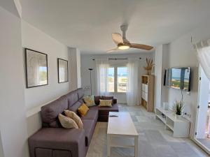 una sala de estar con un sofá y una mesa en Santa Barbara A Beach front apartment with sea view and garage in Conil, en Conil de la Frontera
