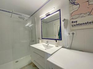 Un baño blanco con lavabo y espejo. en Santa Barbara A Beach front apartment with sea view and garage in Conil, en Conil de la Frontera 14 fotos más