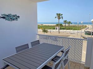 Una mesa y sillas en un balcón con vista a la playa. en Santa Barbara A Beach front apartment with sea view and garage in Conil, en Conil de la Frontera