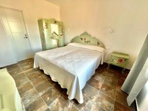 a bedroom with a bed and a tiled floor at Los Naranjos - Alojamiento Rural Sostenible in El Cristo del Espíritu Santo