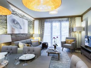 ein Wohnzimmer mit Sofa und Tisch in der Unterkunft Appartement Neuf Centre Courchevel Village, Proche Commerces et Pistes, Parking et Fitness Inclus - FR-1-562-33 in Courchevel