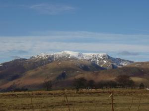 a mountain with snow on top of it in a field at Troutbeck Inn in Troutbeck