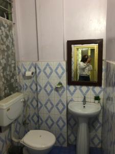 ein Badezimmer mit einem WC, einem Waschbecken und einem Spiegel in der Unterkunft JN Hotel in Kohīma