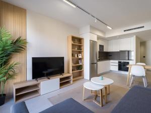 een woonkamer met een televisie en een tafel en stoelen bij VV Arenas de Guanarteme "by henrypole home" in Las Palmas de Gran Canaria