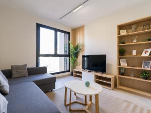 ein Wohnzimmer mit einer Couch, einem Fernseher und einem Tisch in der Unterkunft VV Arenas de Guanarteme "by henrypole home" in Las Palmas de Gran Canaria + 23 Fotos