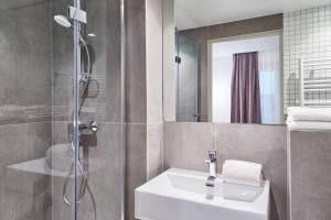 bagno con lavandino e doccia di Hotel Cervantes by Happyculture a Parigi