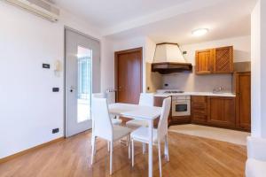 een keuken met een witte tafel en witte stoelen bij Alessia's Flat- Zanica in Bergamo +15 foto's
