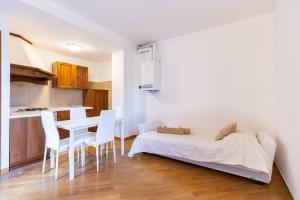 een slaapkamer met een bed, een tafel en stoelen bij Alessia's Flat- Zanica in Bergamo