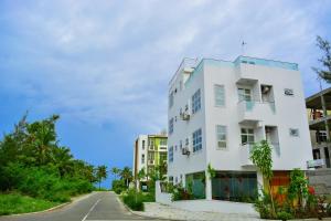 a white building on the side of a road at Beach Palace in Hulhumale