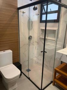 a bathroom with a toilet and a glass shower at Alameda dos Ipês, casa completa, para toda família in Santo Amaro da Imperatriz +39 photos