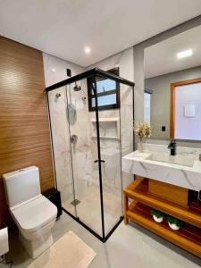 a bathroom with a shower and a toilet and a sink at Alameda dos Ipês, casa completa, para toda família in Santo Amaro da Imperatriz