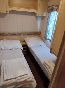 2 łóżka w małym pokoju z oknem w obiekcie Formanka Hotel & Camp w mieście Hustopeče