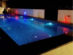 una piscina notturna con luci blu di KshiyOO Holiday Bungalow Resort a Pune
