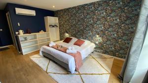 a bedroom with a bed and a wall mural at Hotel LA PLACE in Saint-Amand-Montrond