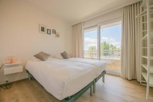 a bedroom with a bed and a large window at Between Waves in Ostend