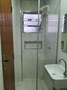 a bathroom with a glass shower and a sink at Suítes Nativa STL in São Thomé das Letras