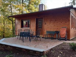 a patio with a table and chairs in front of a cabin at Feriendorf "Am Forsthaus" Mosbach in Mosbach