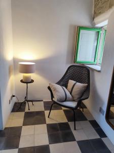Zimmer mit Stuhl und Lampe und kariertem Boden in der Unterkunft Casa Don Michele in Letojanni