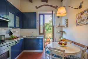 una cucina con armadi blu e un tavolo con un cesto di frutta di Casa Bellesi - Sweet Dreams in Florence a Firenze