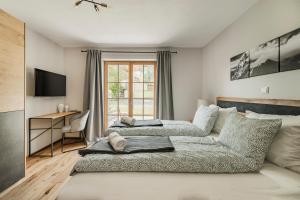 a bedroom with two beds and a desk at Dachstein West Apartment T3 in Russbach am Pass Gschütt