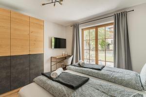 - une chambre avec 2 lits et une fenêtre dans l'établissement Dachstein West Apartment T3, à Russbach am Pass Gschütt