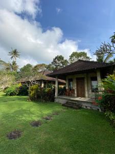 a house with a green lawn in front of it at Geriasemalung in Tirtagangga