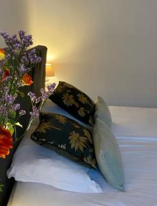 ein Bett mit zwei Kissen und einem Blumenstrauß in der Unterkunft Le Roseau - en plein coeur historique in Annecy