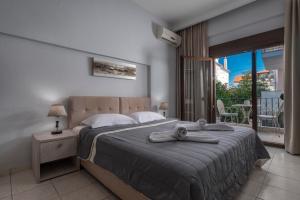 a bedroom with a large bed with towels on it at Adonis Hotel in Pefkochori