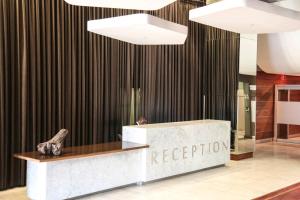a man sitting at a reception desk in a lobby at The Franklin Luxury Apartments in Johannesburg