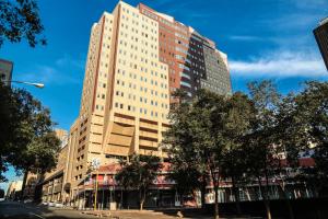 un edificio alto al lado de una calle en The Franklin Luxury Apartments, en Johannesburgo