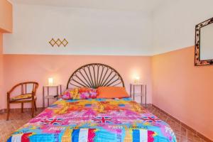 a bedroom with a large bed with a colorful bedspread at Michelangelo's House in Gioiosa Marea