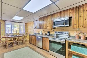 a kitchen with wooden cabinets and a table with chairs at Cozy Getaway Less Than 1 Mi to Cowans Gap State Park! 