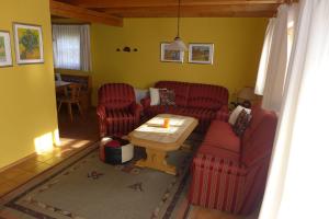 レーゲンにあるHaus-am-Waldのリビングルーム(赤い椅子、コーヒーテーブル付)