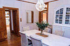 a dining room with a white table and chairs at Killassy House in Graaff-Reinet