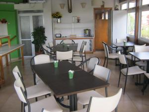 a dining room with tables and white chairs at Super Apart in Miramar