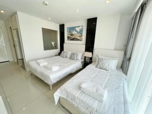 a bedroom with two beds and a window at TRENDY Studio in City Center Residence in Pattaya +11 photos