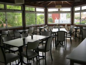 a dining room with tables and chairs and windows at Super Apart in Miramar