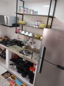 a kitchen with a sink and a refrigerator at Apartamento Conforto in Curitiba