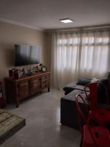 sala de estar con sofá y TV de pantalla plana en Apartamento Conforto, en Curitiba