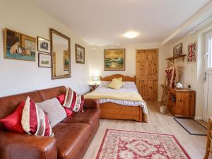 uma sala de estar com um sofá e uma cama em Westoe Hideaway em Llangollen