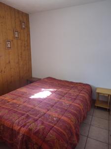 - une chambre avec un lit et une couverture rouge dans l'établissement Boost Your Immo Les Deux Alpes Chalets d'or 792, à Les Deux Alpes
